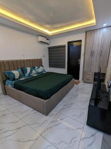 a bedroom with a large bed and a television at Easyinn Shortlet Apartment in Port Harcourt