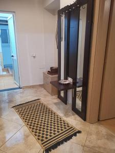 a bathroom with a mirror and a table and a rug at Downtown Authentic Apartment Tirana Myslym Shyri in Tirana
