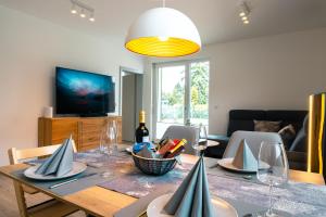 sala de estar con mesa de comedor y copas de vino en Luxuswohnung am Steinhuder Meer - Tierfreundlich - B, en Wunstorf