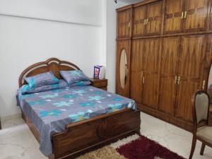 sypialnia z łóżkiem i drewnianą szafką w obiekcie Roxy -Heliopolis w Kairze