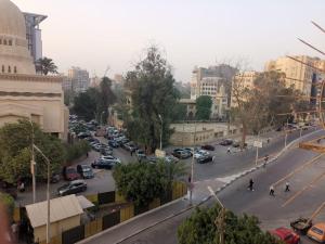 a busy city street with cars parked on the road at Roxy -Heliopolis in Cairo