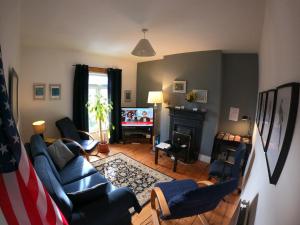 a living room with a couch and chairs and a television at Dublin 6 Rathgar 3km to downtown in Rathgar
