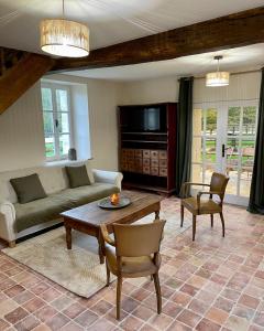sala de estar con sofá y mesa en Gîte du fournil « Chez Nicole », en Ully-Saint-Georges