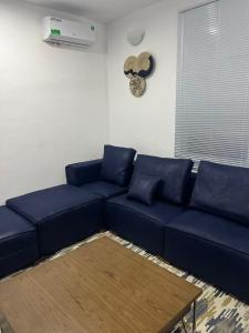 a living room with a blue couch and a fan at OV HOMES in Dar es Salaam