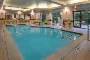 a pool in a hotel with chairs and tables at SpringHill Suites Hagerstown in Hagerstown