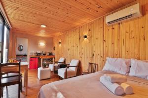 a bedroom with wooden walls and a bed with white towels at Pousada Refúgio Araçá in Morro Redondo