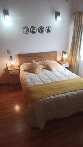 1 dormitorio con 1 cama grande, 2 mesas y 2 lámparas en Alma de Maitén en San Carlos de Bariloche