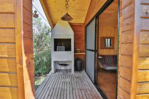 a room with a fireplace in a wooden house at Pousada Refúgio Araçá in Morro Redondo