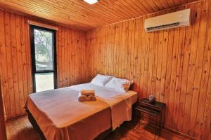 a bedroom with a bed in a wooden wall at Pousada Refúgio Araçá in Morro Redondo