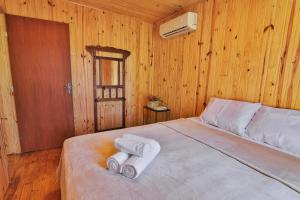 a bedroom with a bed with two towels on it at Pousada Refúgio Araçá in Morro Redondo