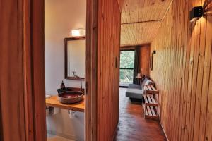 a bathroom with a sink and a wooden wall at Pousada Refúgio Araçá in Morro Redondo