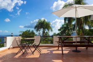 a patio with an umbrella and a table and chairs at Villa Colinas Del Cielo in San Cristóbal
