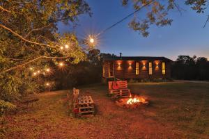a fire pit in front of a log cabin at night at Pousada Refúgio Araçá in Morro Redondo