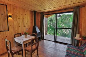 a dining room with a table and a large window at Pousada Refúgio Araçá in Morro Redondo