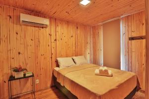 a bedroom with a bed in a wooden wall at Pousada Refúgio Araçá in Morro Redondo