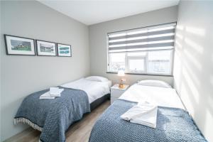 two beds in a small room with a window at Guesthouse Keflavik by Reykjavik Keflavik Airport in Keflavík