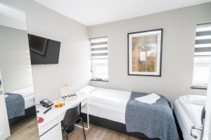 um pequeno quarto de hotel com uma cama e uma secretária em Guesthouse Keflavik by Reykjavik Keflavik Airport em Keflavík