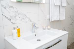 a white bathroom with a sink and a mirror at Guesthouse Keflavik by Reykjavik Keflavik Airport in Keflavík