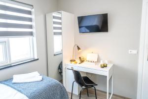a bedroom with a desk and a bed and a desk with a chair at Guesthouse Keflavik by Reykjavik Keflavik Airport in Keflavík +19 photos