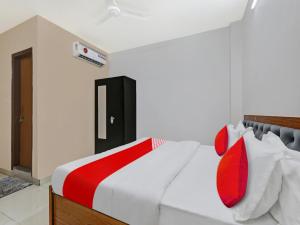a bedroom with a white bed with red pillows at OYO Flagship 81216 Hotel Silver Grand in Lucknow