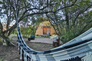 a hammock in front of a log cabin at Pousada Refúgio Araçá in Morro Redondo