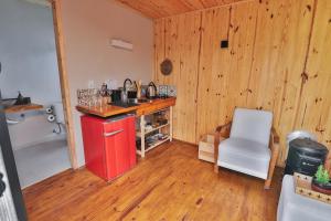 a kitchen with a red refrigerator and a chair in a room at Pousada Refúgio Araçá in Morro Redondo