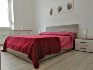 a bedroom with a bed with a red blanket on it at Appartamento comodo per Milano e Rho Fiera in Milan
