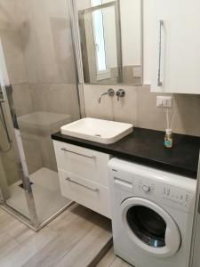 y baño con lavadora y lavamanos. en Appartamento comodo per Milano e Rho Fiera en Milán