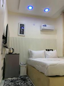 una camera d'albergo con letto e TV di Bott Extended Stay ad Abuja