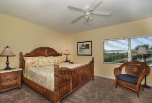 um quarto com uma cama e uma ventoinha de tecto em Spacious condo with balcony overlooking the natural preserve OW10-307 em New Smyrna Beach