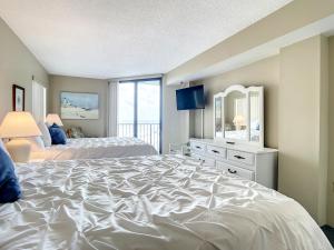 1 dormitorio grande con 2 camas y espejo en Ocean View with a beachfront pool at Ocean Trillium Condo 504, en New Smyrna Beach