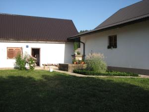 a white house with a black roof and a yard at House Nada in Donji Babin Potok