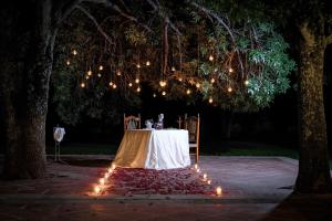 una mesa con sillas y luces bajo un árbol en Hotel Hacienda Cantalagua Golf en Contepec