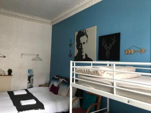 1 Schlafzimmer mit 2 Etagenbetten und einer blauen Wand in der Unterkunft THE EDINBURGH TOWNHOUSE - Boutique Hostel in Edinburgh