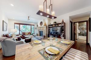 a living room with a table and a fireplace at Snowy Spruce Sanctuary in Edwards