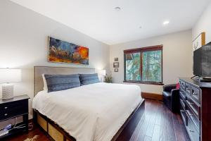 a bedroom with a bed and a flat screen tv at Snowy Spruce Sanctuary in Edwards +27 photos