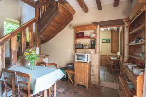 eine Küche mit einem Tisch und einer Blumenvase darauf in der Unterkunft Domaine Moulin de Boiscorde in Rémalard