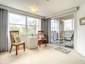 ein Wohnzimmer mit Tisch und Stühlen und Fenstern in der Unterkunft Beautiful 3 bedroom 2 bath condo with Breath taking views of the ocean. OW1-407 in New Smyrna Beach