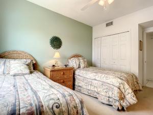 ein Schlafzimmer mit zwei Betten und einem Tisch mit Lampe in der Unterkunft Beautiful 3 bedroom 2 bath condo with Breath taking views of the ocean. OW1-407 in New Smyrna Beach + 51 Fotos