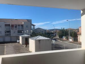 einen Balkon mit Blick auf einen Parkplatz in der Unterkunft Appartement T2 lumineux in Frontignan