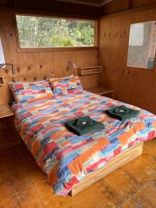 ein Bett mit zwei Hüten auf einem Zimmer in der Unterkunft Base Camp Tasmania in New Norfolk