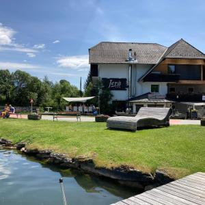 a building with a bench next to a river at Jerà am Furtnerteich Hotel-Ristorante&Relax in Mariahof