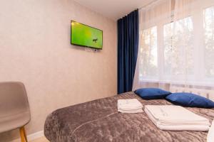 a hotel room with a bed with blue pillows and a window at MYFREEDOM Апартаменти пр-т Воскресенський in Kyiv