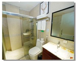 een badkamer met een toilet, een wastafel en een douche bij pristinehotel in Manilla