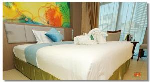 een slaapkamer met een bed met twee zwanen erop bij pristinehotel in Manilla
