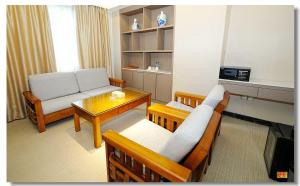 een woonkamer met een bank en een tafel bij pristinehotel in Manilla