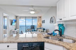 a kitchen with a sink and a living room at Beachfront 2 Bed at Popular Seawinds!!! in Marco Island