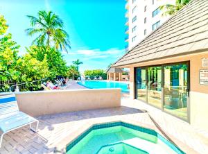a swimming pool with a bench next to a building at Beachfront 2 Bed at Popular Seawinds!!! in Marco Island
