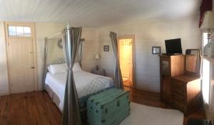 um quarto com uma cama de dossel em Historic Seaton Springs Farm B&B - James Tipton En-Suite Triple Room em Sevierville