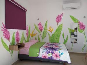 a bedroom with a flower mural on the wall at Casa Narcisa Studio Apartaments in Mérida